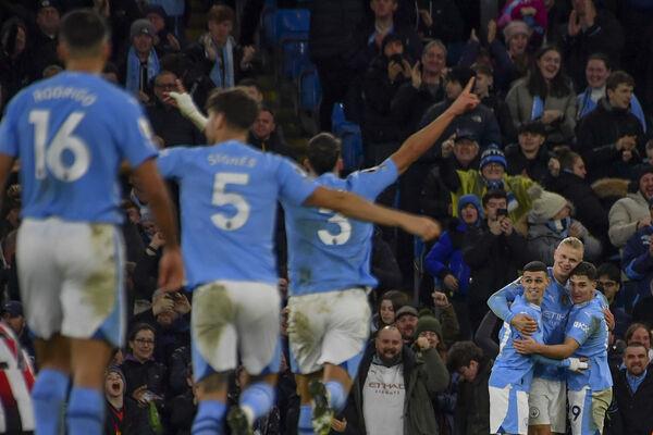 Manchester City's Erling Haaland celebrates with teammates after scoring his side's opening goal during the English Premier League soccer match between Manchester City and Brentford at the Etihad stadium in Manchester, England, Tuesday, Feb. 20, 2024. (AP Photo/Rui Vieira)