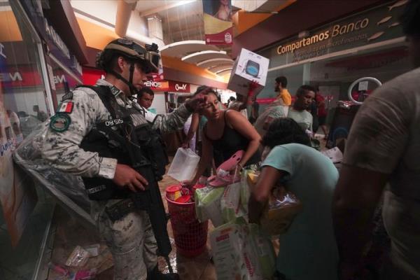 A Mexican Natio<em></em>nal Guard soldier tries to stop looting in a shopping mall after Hurricane Otis ripped through Acapulco, Mexico, on Oct. 25, 2023. 